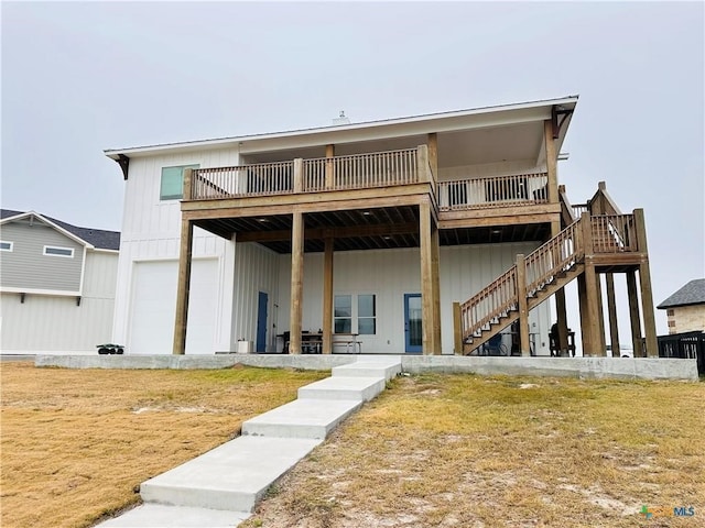 rear view of property featuring a garage and a lawn