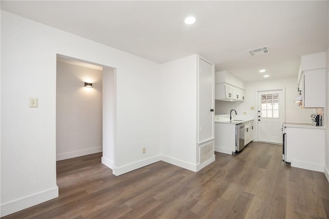 kitchen featuring white cabinets, dark hardwood / wood-style flooring, range, and stainless steel dishwasher