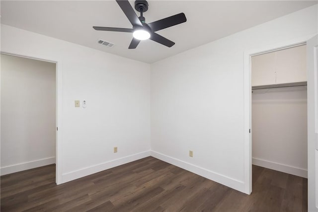 unfurnished bedroom with a closet, ceiling fan, dark hardwood / wood-style flooring, and a spacious closet