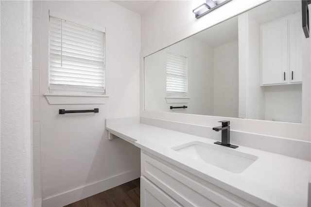 bathroom with a wealth of natural light, vanity, and hardwood / wood-style flooring