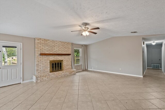 unfurnished living room featuring a fireplace, light tile patterned floors, and a healthy amount of sunlight