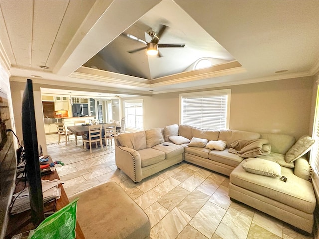 living room featuring ceiling fan, a raised ceiling, and crown molding