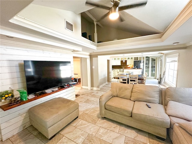 living room with ceiling fan, ornamental molding, and vaulted ceiling