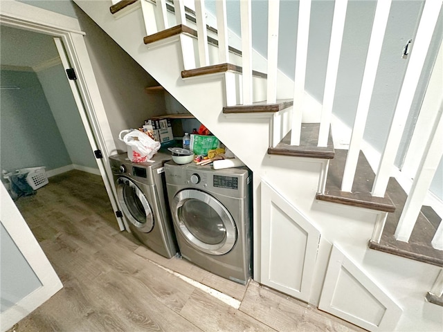 clothes washing area featuring light hardwood / wood-style floors and separate washer and dryer