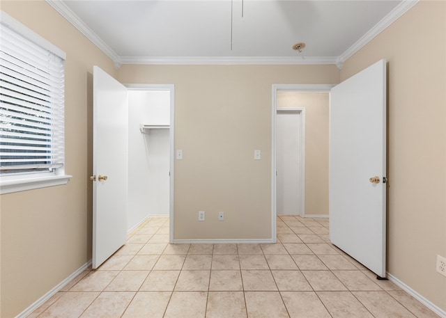 unfurnished bedroom with a spacious closet, ornamental molding, light tile patterned floors, and a closet