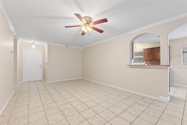 spare room with ceiling fan, crown molding, and light tile patterned floors