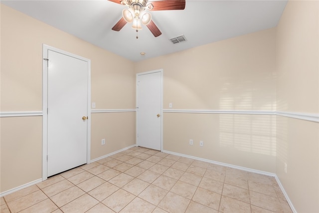 tiled empty room with ceiling fan