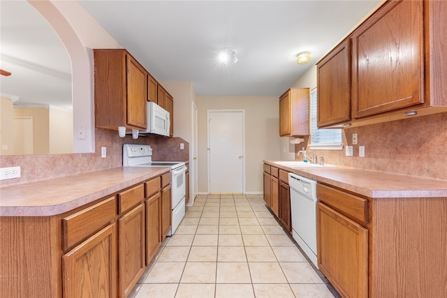 kitchen featuring light tile patterned floors, white appliances, and sink