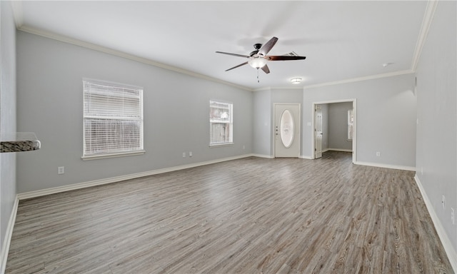 unfurnished living room with ceiling fan, crown molding, wood finished floors, and baseboards