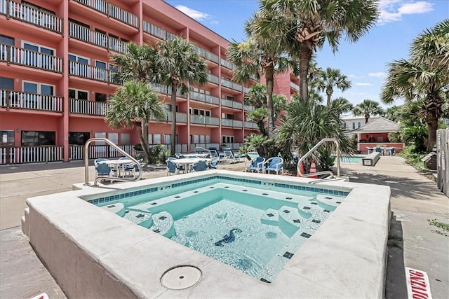 view of pool with a hot tub