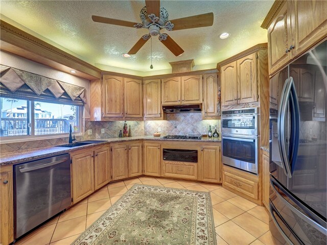 15806 Punta Espada, Corpus Christi, TX 78418 - kitchen featuring stainless steel appliances, a sink, under cabinet range hood, light tile patterned flooring, and a textured ceiling