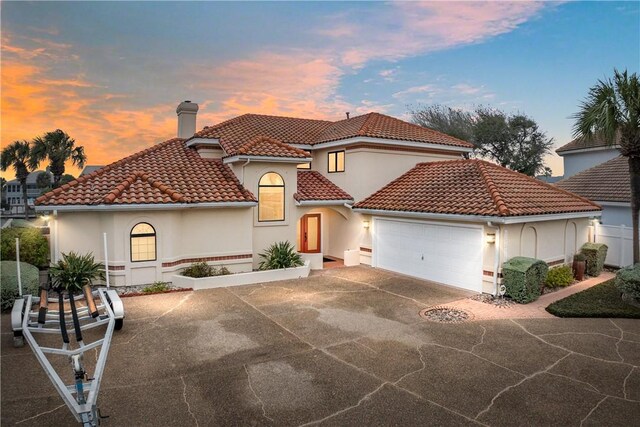 15806 Punta Espada, Corpus Christi, TX 78418 - mediterranean / spanish-style house featuring a chimney, a tile roof, an attached garage, concrete driveway, and stucco siding