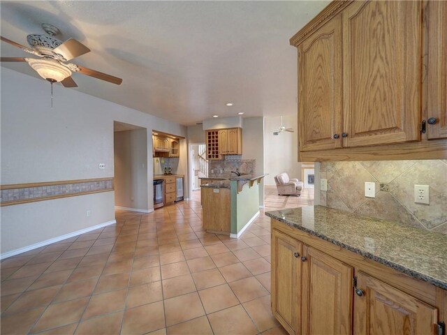 15806 Punta Espada, Corpus Christi, TX 78418 - kitchen with ceiling fan, light tile patterned floors, decorative backsplash, dark stone counters, and recessed lighting