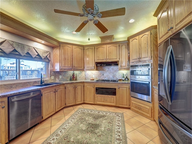 kitchen featuring appliances with stainless steel finishes, sink, light tile patterned floors, and backsplash