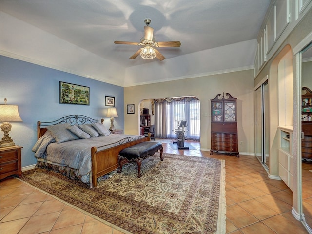 bedroom featuring ornamental molding, a raised ceiling, ceiling fan, and light tile patterned flooring