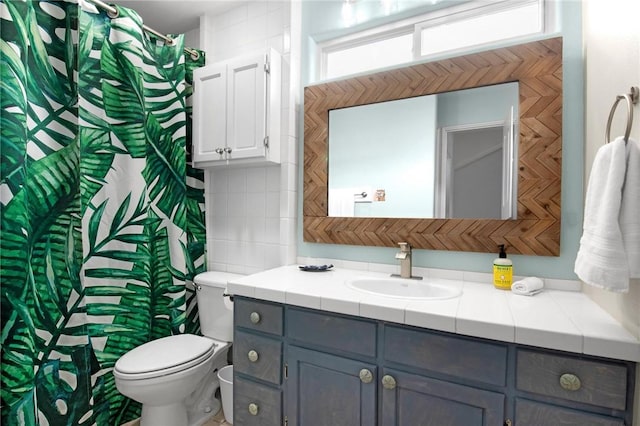 full bath with toilet, vanity, and curtained shower