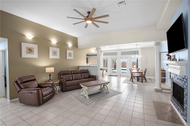living area with a ceiling fan, a fireplace, light tile patterned floors, ornate columns, and baseboards