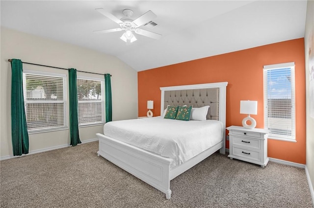 bedroom with lofted ceiling, light colored carpet, baseboards, multiple windows, and a ceiling fan