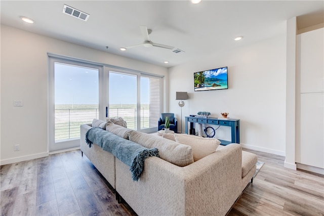 living room with hardwood / wood-style floors, a wealth of natural light, and ceiling fan