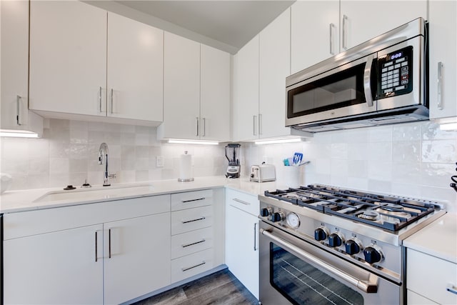 kitchen with dark hardwood / wood-style flooring, backsplash, appliances with stainless steel finishes, and white cabinets