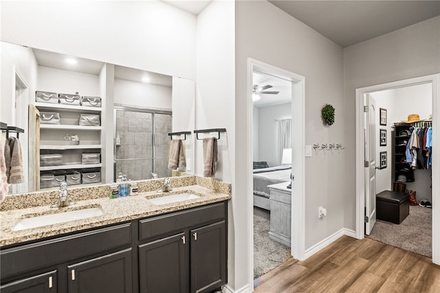 1345 Regents Park, Corpus Christi, TX 78415 - ensuite bathroom with wood finished floors, a walk in closet, double vanity, a stall shower, and baseboards