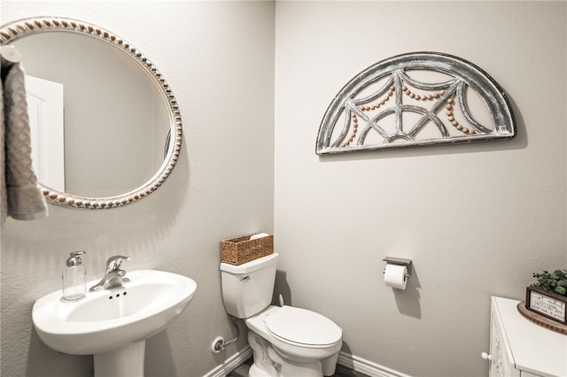 1345 Regents Park, Corpus Christi, TX 78415 - half bathroom with baseboards, toilet, and a sink