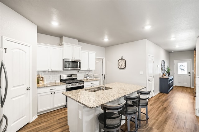 1345 Regents Park, Corpus Christi, TX 78415 - kitchen with stainless steel appliances, a sink, dark wood finished floors, backsplash, and an island with sink