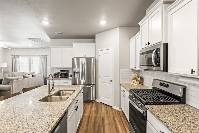 1345 Regents Park, Corpus Christi, TX 78415 - kitchen featuring stainless steel appliances, a sink, open floor plan, dark wood-style flooring, and white cabinets