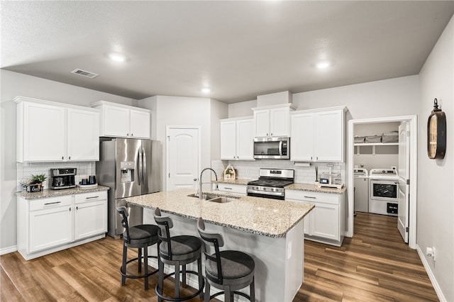 1345 Regents Park, Corpus Christi, TX 78415 - kitchen with appliances with stainless steel finishes, separate washer and dryer, a sink, backsplash, and dark wood-style flooring