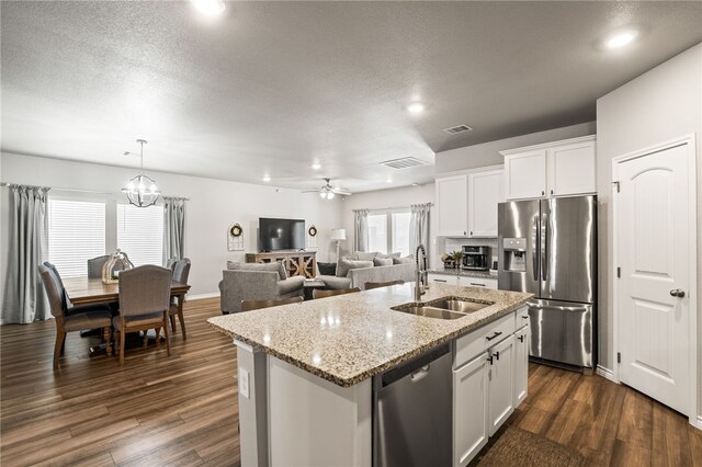 1345 Regents Park, Corpus Christi, TX 78415 - kitchen with stainless steel appliances, a sink, a center island with sink, dark wood-style flooring, and a textured ceiling