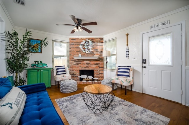 1703 Bayshores, Rockport, TX 78382 - living room featuring wood finished floors, ceiling fan, a fireplace, and ornamental molding