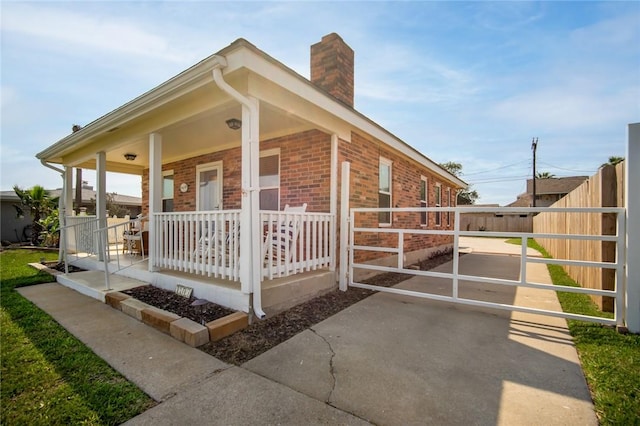 1703 Bayshores, Rockport, TX 78382 - view of side of property featuring brick siding, a chimney, and covered porch