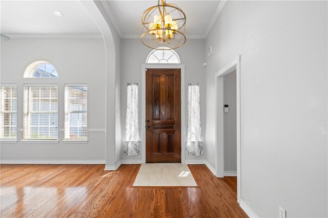 108 Black Diamond, Portland, TX 78374 - foyer with a chandelier, arched walkways, wood finished floors, baseboards, and crown molding