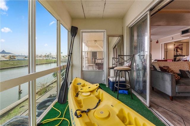 sunroom featuring a water view