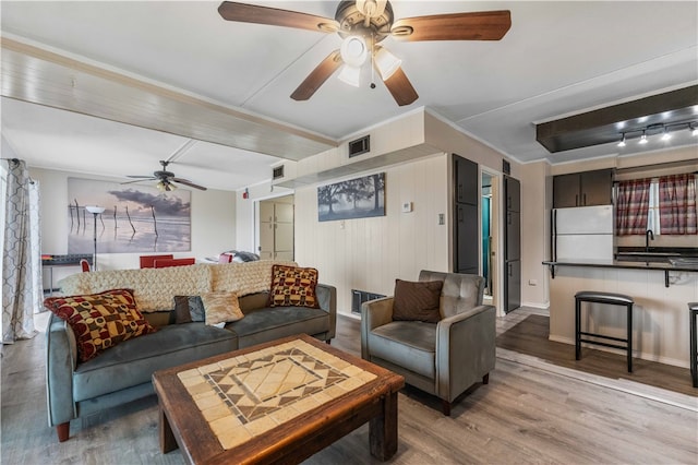 living room featuring sink, wood-type flooring, and ceiling fan