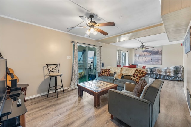 living room with ornamental molding, light hardwood / wood-style flooring, and ceiling fan