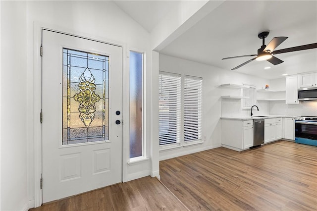 entryway with ceiling fan, light hardwood / wood-style floors, and lofted ceiling