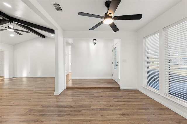 empty room with hardwood / wood-style floors, lofted ceiling with beams, and ceiling fan