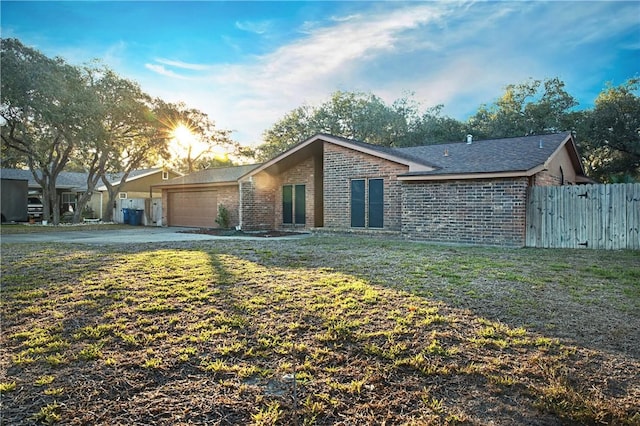 ranch-style home with a garage and a front lawn