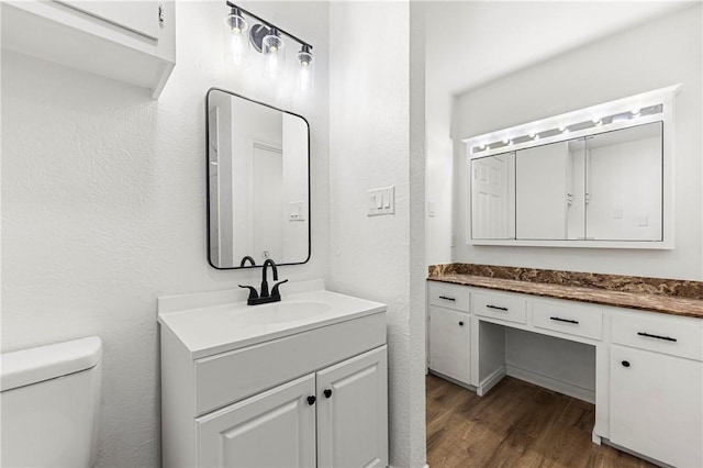 bathroom with hardwood / wood-style flooring, vanity, and toilet