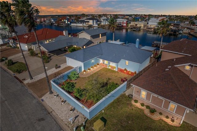 aerial view at dusk featuring a water view