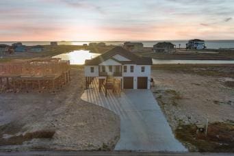 10 Westpointe Dr, Rockport, TX 78382 - view of front of house featuring a water view, driveway, and an attached garage