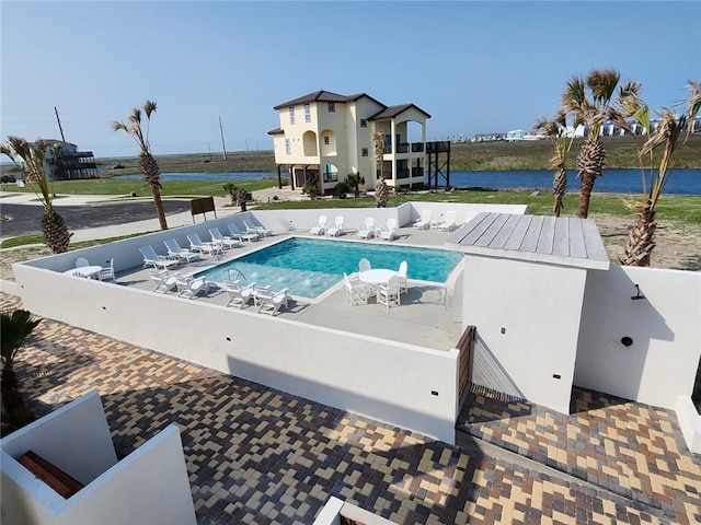 community pool with a patio and a water view
