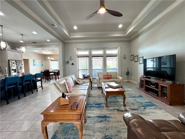 living room featuring light tile patterned floors, ceiling fan with notable chandelier, a raised ceiling, and crown molding