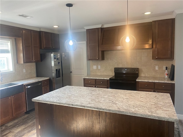 kitchen with stainless steel appliances, custom range hood, dark hardwood / wood-style floors, light stone countertops, and pendant lighting