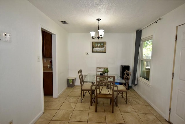 dining room with visible vents, a textured ceiling, light tile patterned flooring, baseboards, and a chandelier