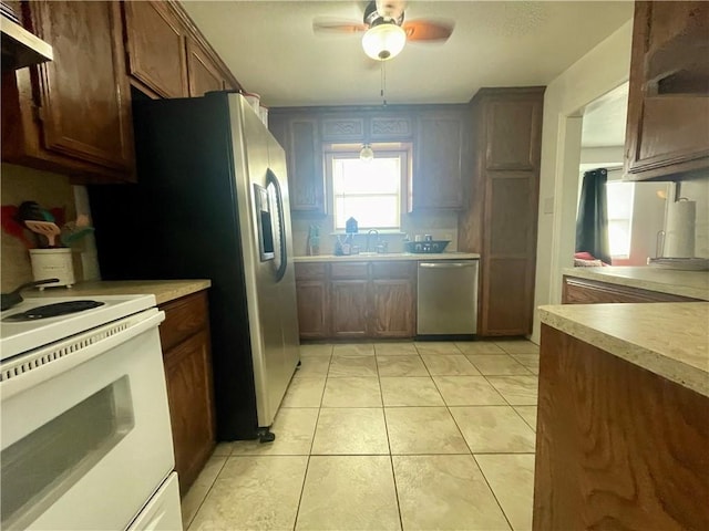kitchen with dishwasher, light countertops, light tile patterned floors, electric stove, and a ceiling fan
