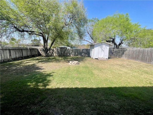 view of yard featuring a storage shed, an outbuilding, and a fenced backyard