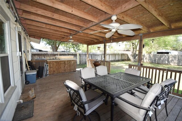 wooden terrace with a ceiling fan, outdoor dining area, and a fenced backyard
