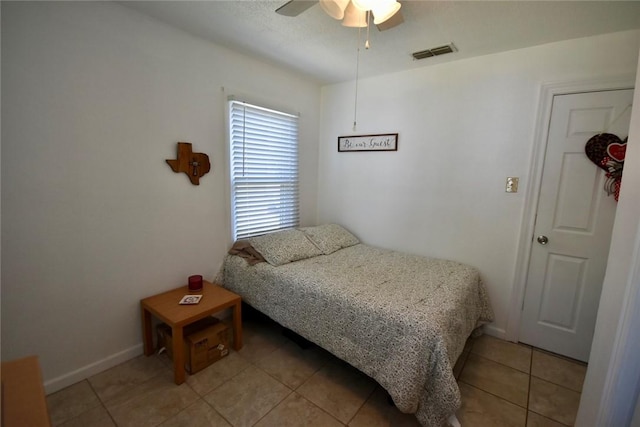 bedroom with light tile patterned floors, visible vents, baseboards, and a ceiling fan
